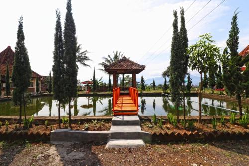 a garden with a gazebo in front of a pond at Hotel Agung Permata Artha in Cipanas