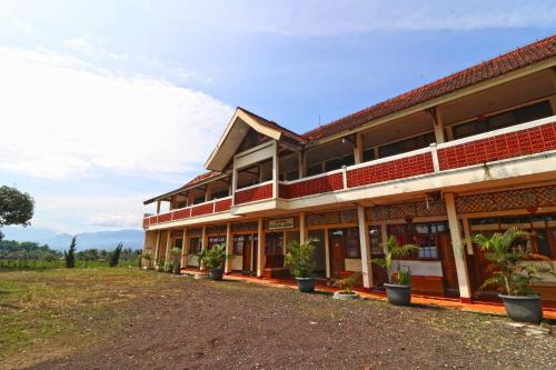 a building with potted plants in front of it at Hotel Agung Permata Artha in Cipanas