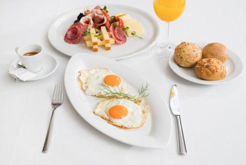 a white table with plates of breakfast foods and drinks at Bioenergy Resort Salinera Apartments in Strunjan