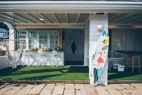 een huis met een surfplank op de veranda bij Yellow's Kenting B&B in Nanwan