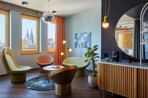 a living room with chairs and a table at 25hours Hotel The Circle in Cologne
