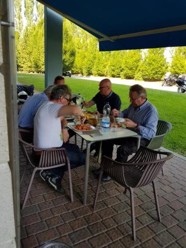 un grupo de hombres sentados en una mesa comiendo comida en hotel IL POLO, en Mortara