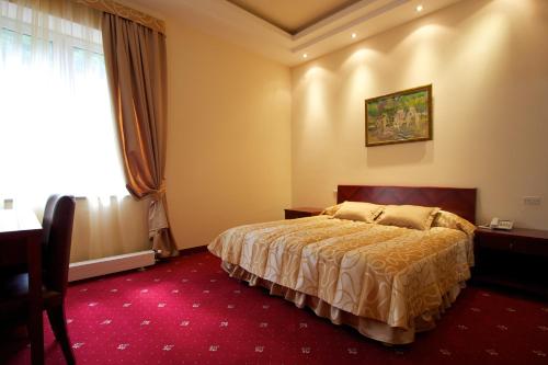 a bedroom with a bed and a desk and a window at Best Resort Aghveran in Arzakan