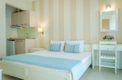 a bedroom with a bed with two pillows and a chair at Palm Studios in Limenas