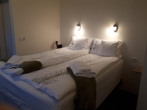 a large bed with white sheets and pillows at B&B Sólheimar 9 in Akureyri
