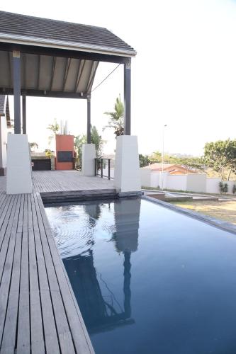 a swimming pool with a wooden deck and a pavilion at Westwood Skye 12 Grace Avenue in Durban