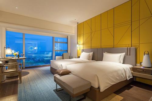 a hotel room with two beds and a large window at Tianyuan Grand Hotel Xiamen in Xiamen