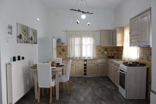 una cocina con electrodomésticos blancos, mesa y sillas en Mommy's House, en Angeliana