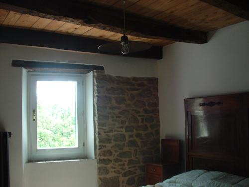 een slaapkamer met een stenen muur en een raam bij Ca' Morano in Pavullo nel Frignano