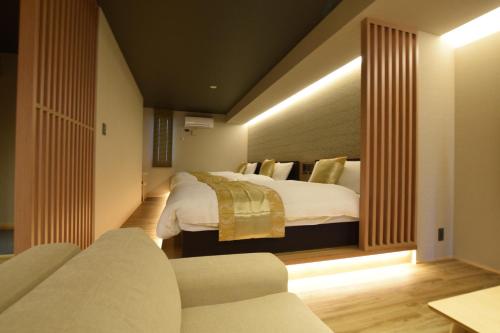 a hotel room with a bed and a couch at GRAND BASE Beppu Ekimae in Beppu
