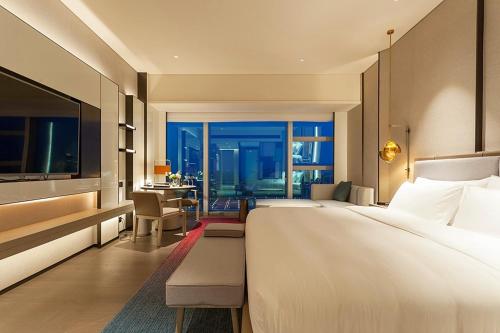 a hotel room with a large bed and a desk at Tianyuan Grand Hotel Xiamen in Xiamen