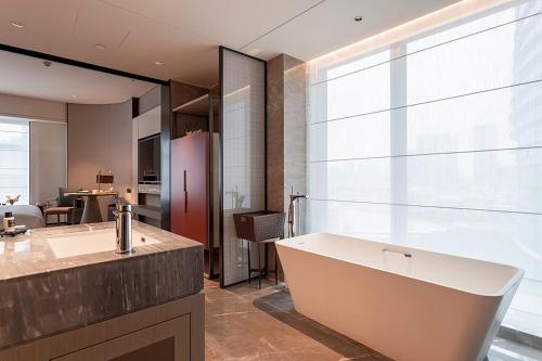 a bathroom with a tub and a large window at Tianyuan Grand Hotel Xiamen in Xiamen