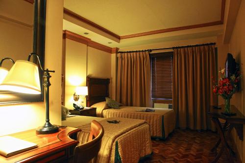 Pokój hotelowy z 2 łóżkami i biurkiem w obiekcie Herald Suites w mieście Manila