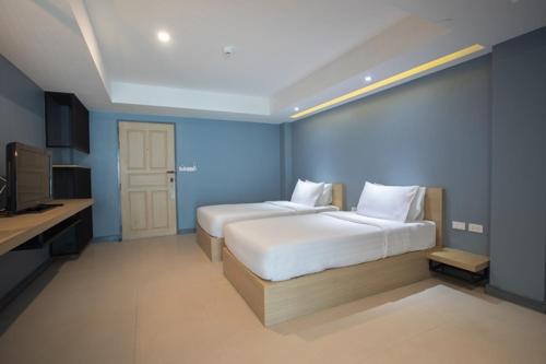 a bedroom with two beds in a blue room at Nora LakeView in Chaweng