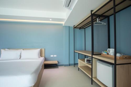 a bedroom with a bed and a blue wall at Nora LakeView in Chaweng