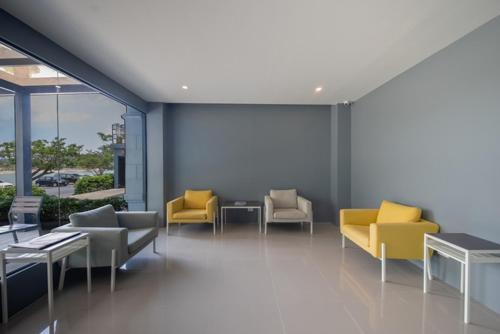 a lobby with couches and tables and yellow chairs at Nora LakeView in Chaweng