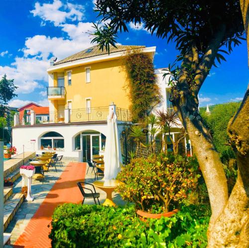 un hôtel avec des tables et des chaises et un bâtiment dans l'établissement Hotel Bellavista, à San Bartolomeo al Mare