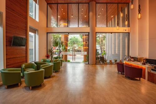 a lobby with a waiting area with green chairs at An Phu Hotel in Phú Quốc