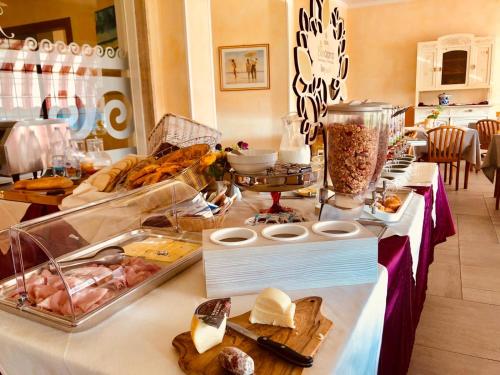 a buffet with cheese and other food on a table at Hotel Bellavista in San Bartolomeo al Mare