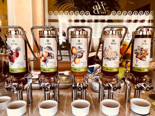 four bottles of wine sitting on a counter with cups at Hotel Bellavista in San Bartolomeo al Mare
