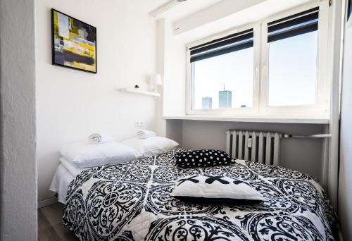 Elegant Apartment Panoramic في وارسو: غرفة نوم بسرير أسود وبيض مع وسادتين