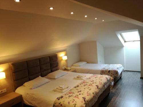 a hotel room with two beds and a window at Filokalia Hotel in Ioannina
