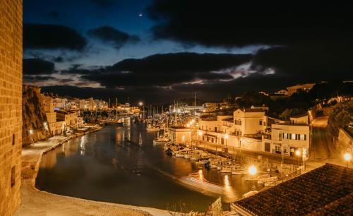 a view of a river at night with buildings at Faustino Gran Relais & Chateaux in Ciutadella