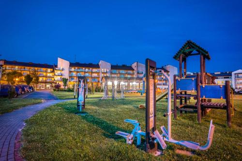 a playground in a park in front of a building at Hotel ***NAT Sarbinowo in Sarbinowo