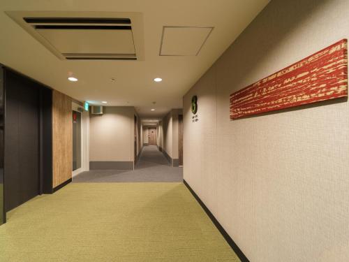 a hallway with a yellow carpet in a building at Super Hotel Kyoto Shijokawaramachi in Kyoto