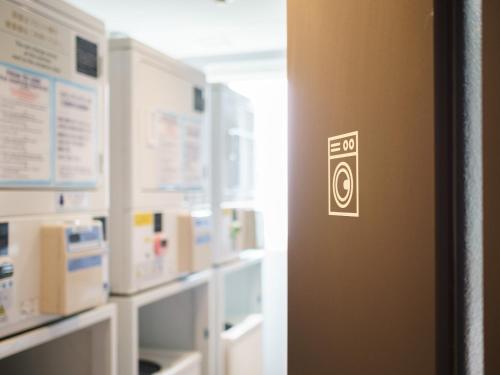 a door with a sign on it in a room at Super Hotel Kyoto Shijokawaramachi in Kyoto