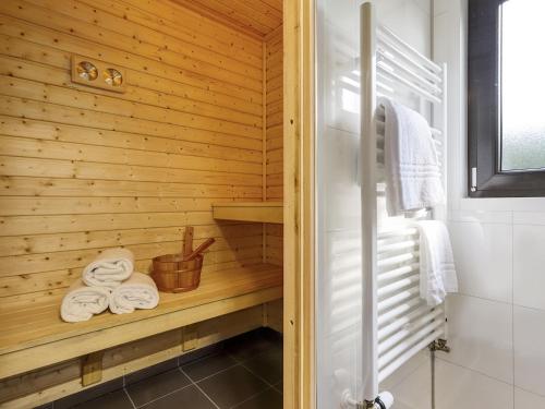 een badkamer met een sauna en handdoeken op een plank bij Relaxing Forest Hideaway in Markelo
