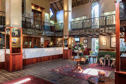 a lobby of a building with a staircase and a lobby at Misty Hills Country Hotel, Conference Centre & Spa in Muldersdrift