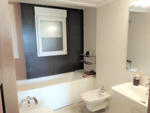 a bathroom with a tub and a toilet and a sink at Monte Corona in Ador