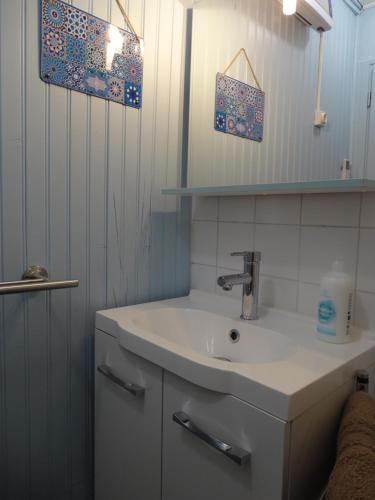 une salle de bain blanche avec un lavabo et un miroir dans l'établissement La Marguerite sur Gartempe, à Châteauponsac