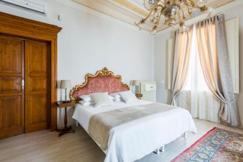 a bedroom with a large white bed and a chandelier at Villa Savioli Room & Breakfast in Bologna