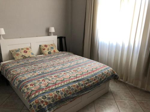 ein Schlafzimmer mit einem Bett mit einer Decke und einem Fenster in der Unterkunft Marco simone golf club in Marco Simone