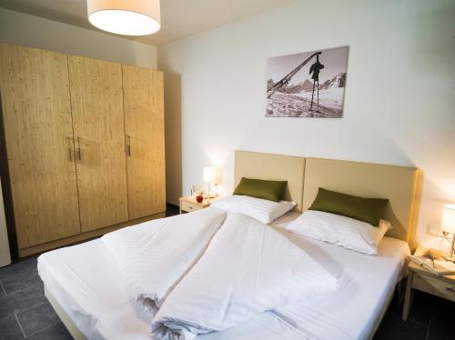 a bedroom with a large white bed with two pillows at AlpenParks Chalet & Apartment AreitXpress in Zell am See