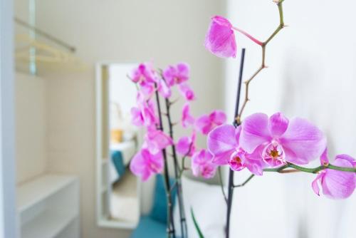un ramo de flores rosas en un jarrón azul en Villa Savioli Room & Breakfast, en Bolonia