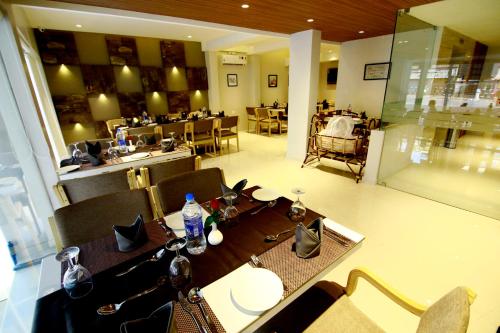 un comedor con mesa y sillas y un restaurante en HOTEL PANACEA VENTURES, en Kollam