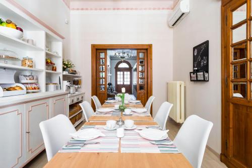 een eetkamer met een lange tafel en witte stoelen bij Villa Savioli Room & Breakfast in Bologna