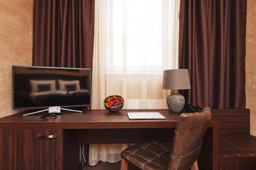 a room with a desk with a television and a window at Penzion BERG in Bratislava