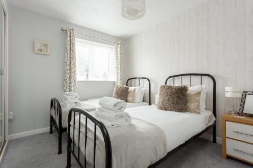2 aparte bedden in een slaapkamer met een raam bij Solstice in Poole