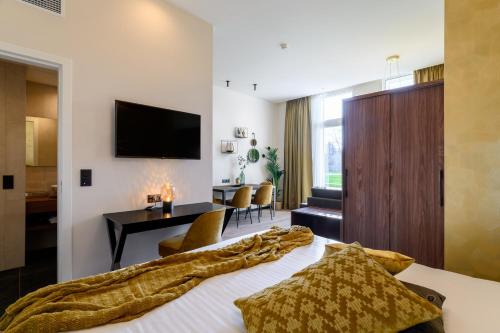 een hotelkamer met een bed en een woonkamer bij Leopold Hotel Oudenaarde in Oudenaarde