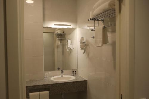 um banheiro com uma pia e um espelho em Hotel Solar do Rebolo em Oliveira do Hospital