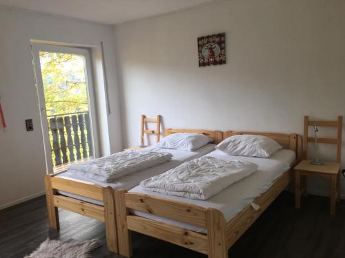 two twin beds in a room with a window at Sauerland vakantiehuisje in Diemelsee