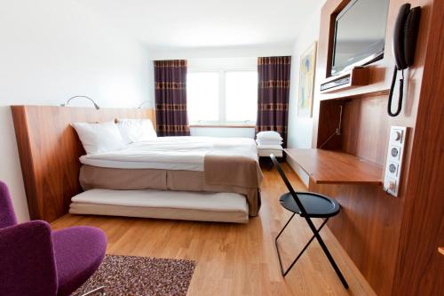 a hotel room with a bed and a tv at Quality Hotel Grand, Borås in Borås