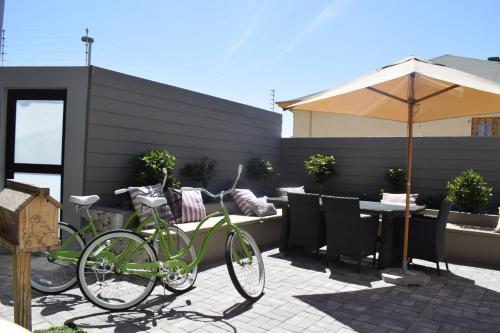 two bikes parked on a patio with an umbrella at Driftwood Guesthouse in Swakopmund