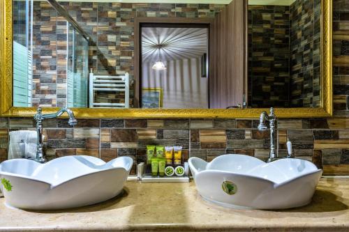 2 lavabos blancos en un baño con espejo en To Hani Tou Kokkini, Pelion en Chania