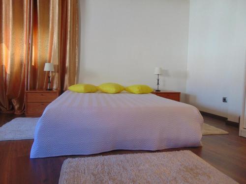 a bedroom with a bed with yellow pillows on it at Casa Do Prado in Macedo de Cavaleiros