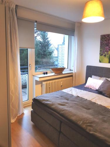 sypialnia z łóżkiem i dużym oknem w obiekcie Neues, ruhiges Apartment Nordic in Düsseldorf-Nord w mieście Düsseldorf